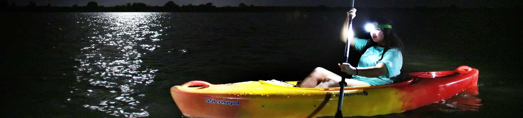 Student on a moon light paddle in a canoe